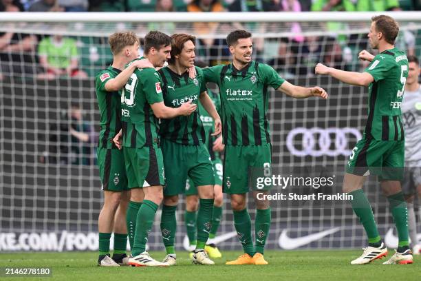 Ko Itakura of Borussia Mönchengladbach celebrates scoring his team's first goal with teammates during the Bundesliga match between VfL Wolfsburg and...