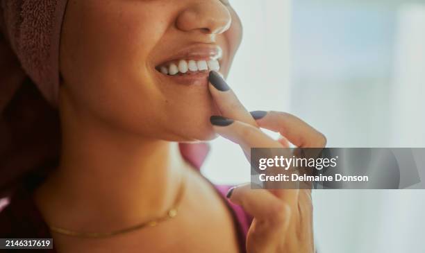 a close-up shot of a woman applying lip balm - lip balm stock pictures, royalty-free photos & images