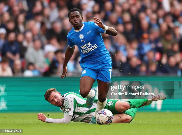 Matt Butcher of Wycombe Wanderers battles for possession with Kwame Poku of Peterborough United during the Bristol Street Motors Trophy Final between...