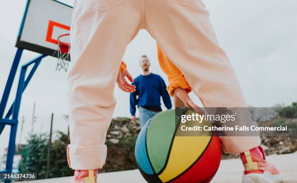 a child plays basketball with her father, who guards the basketball hoop - championship round two stock pictures, royalty-free photos & images