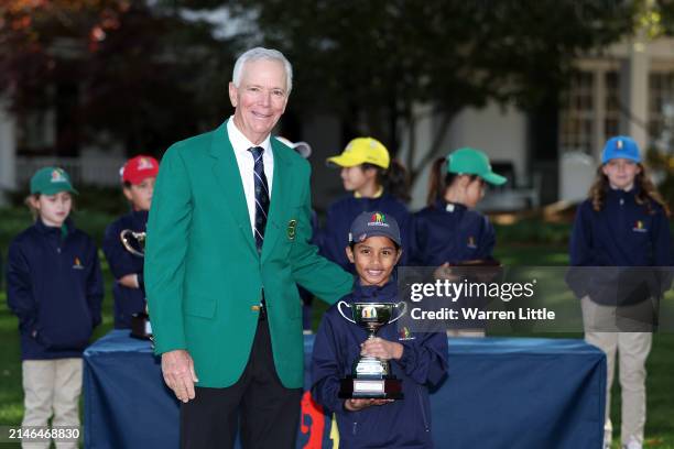 Trisha Lobo third overall in the Girl's 7-9 group poses with Larry Mize during the Drive, Chip and Putt Championship at Augusta National Golf Club at...