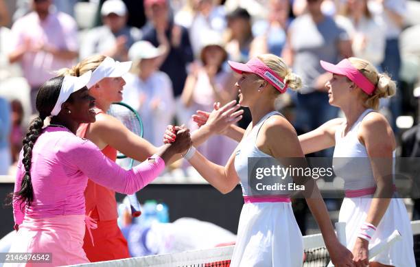 Ashlyn Krueger and Sloane Stephens of the United States are congratulated by Lyudmyla Kichenok and Nadiia Kichenok of the Ukraine after the win of...