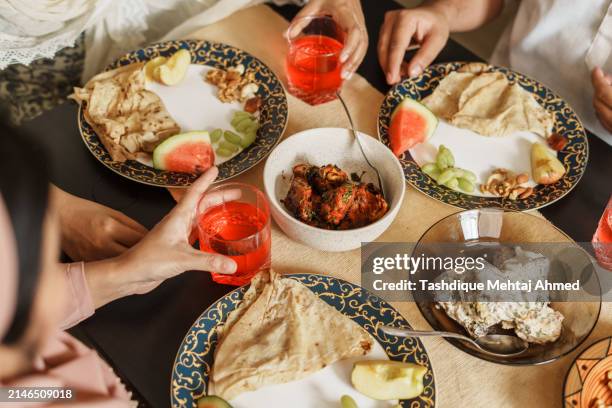 close-up shot of hands holding food. - indian restaurant stock pictures, royalty-free photos & images
