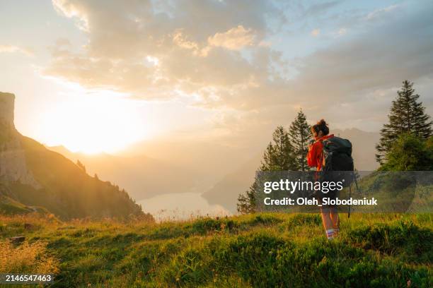 woman in red coat hiking in swiss alps in summer - mountain ridge stock pictures, royalty-free photos & images