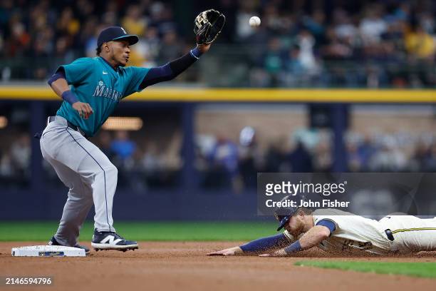 Oliver Dunn of the Milwaukee Brewers slides under the tag of Jorge Polanco of the Seattle Mariners for a stolen base in the first inning at American...