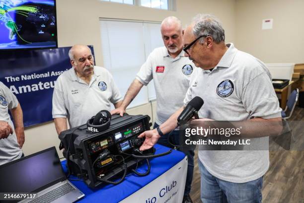 Richie Geraci, of Shirley, left, Ed Wilson, of Shirley, center, and Bob Ciappa, of Farmingville, right, work with ham radio equipment during a...