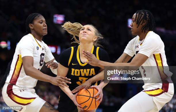 Sydney Affolter of the Iowa Hawkeyes drives to the rim as Sania Feagin and Ashlyn Watkins of the South Carolina Gamecocks defend in the second half...