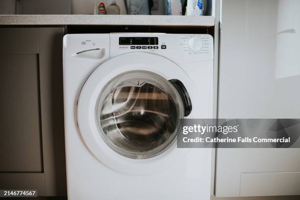 simple image of a modern washing machine - washing machine front stock pictures, royalty-free photos & images