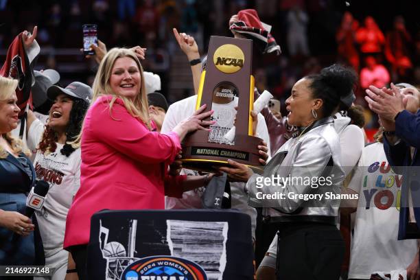 Lisa Peterson, Chair of the Division I Women's Basketball Committee hands head coach Dawn Staley of the South Carolina Gamecocks the trophy after...