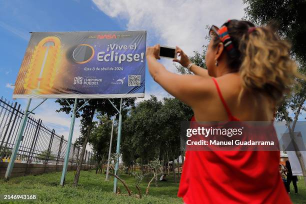 Woman takes a photo of a poster announcing the eclipse on April 7, 2024 in Torreon, Mexico. According to experts, the west coast of Mexico will be...