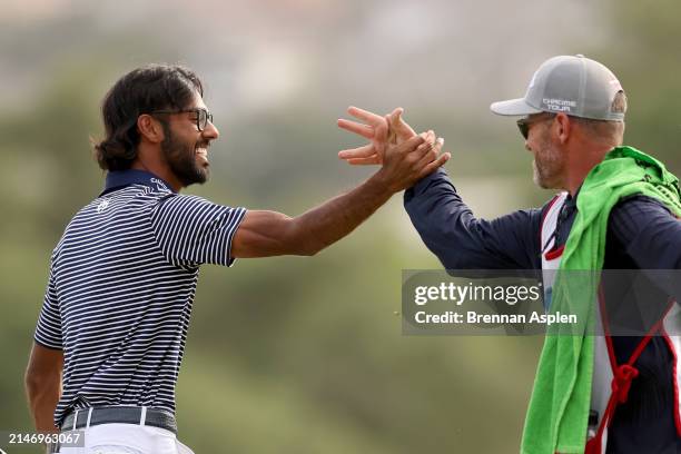 Akshay Bhatia of the United States celebrates after winning the Valero Texas Open on the 18th hole of the first playoff with his caddie Ryan Jamison...