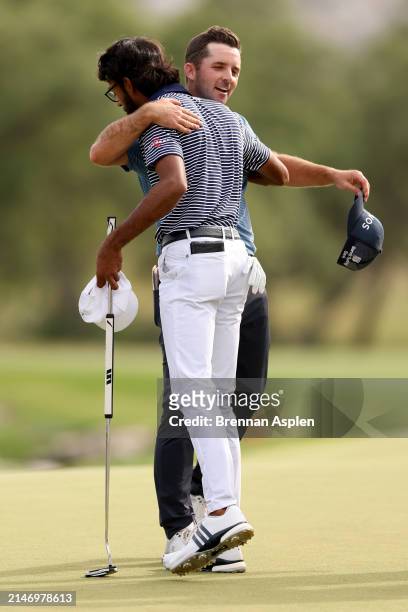 Akshay Bhatia of the United States shakes hands with Denny McCarthy after finishing their rounf on the 18th hole of the first playoff with his caddie...