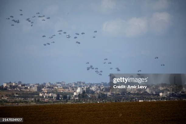 An airplane drops aid into Gaza as seen from the Israeli side of the border on April 10, 2024 in Southern Israel, Israel. April 7th marked six months...