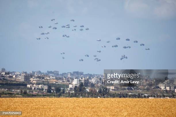 An airplane drops aid into Gaza as seen from a position from the Israeli side of the border on April 10, 2024 in Southern Israel, Israel. April 7th...