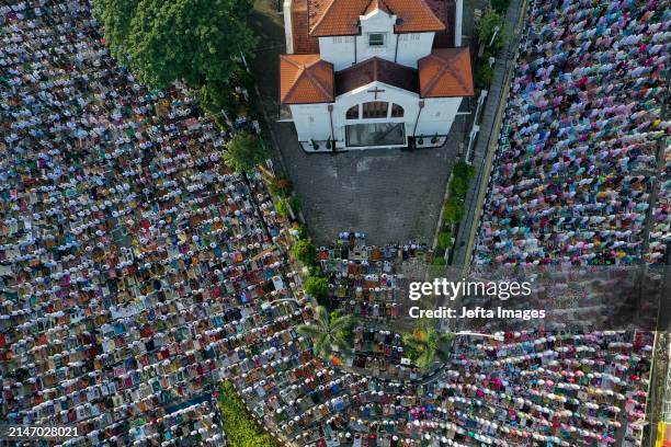 People take part in Eid al-Fitr prayers outside a church in Jakarta, Indonesia. Eid al-Fitr is a religious holiday celebrated by Muslims around the...