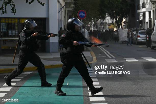 Policemen aim rubber bullets weapons against members of social organizations during a demonstration against the recent economic measures introduced...