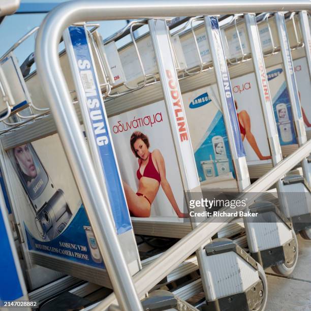 Airport baggage trolleys featuring a woman wearing a bikini at Athens airport, on 18th February 2000, in Athens, Greece.