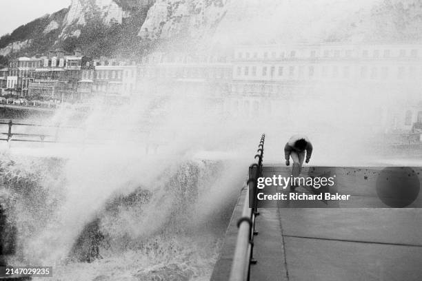Man ducks to avoid the spray during high winds at Dover Eastern Dock, on Dover seafront, on 21st October 1989, in Dover, Kent, England.