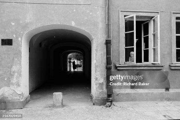 Young Polish boy watches the street from his window, on 26th June 1990, in Warsaw, Poland.