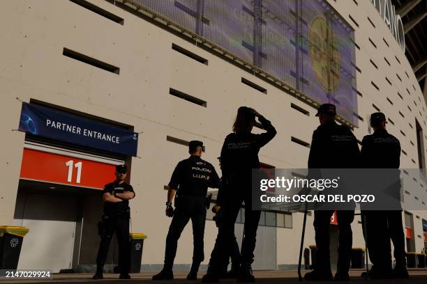 Spanish national police officers patrol outside of the Metropolitano stadium prior to the UEFA Champions League quarter final first leg football...