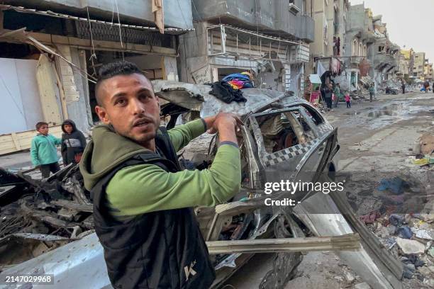 Man gestures in front of the car in which three sons of Hamas leader Ismail Haniyeh were reportedly killed in an Israeli air strike in al-Shati camp,...