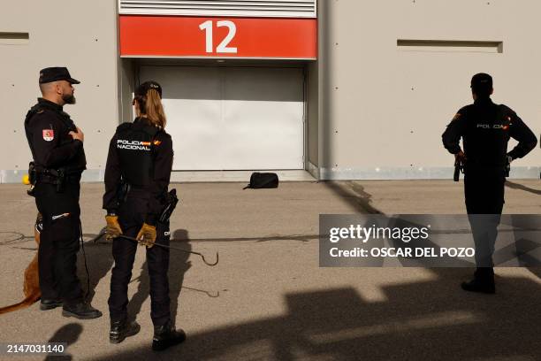 Spanish national police officers stand next to a backpack left outside of the Metropolitano stadium prior to the UEFA Champions League quarter final...