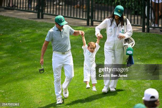 Rickie Fowler with his wife, Allison Stokke, swing their daughter, Maya, during the Par-3 Contest, prior to Masters Tournament at Augusta National...