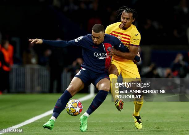 Paris Saint-Germain's French forward Kylian Mbappe and Barcelona's French defender Jules Kounde fight for the ball during the UEFA Champions League...