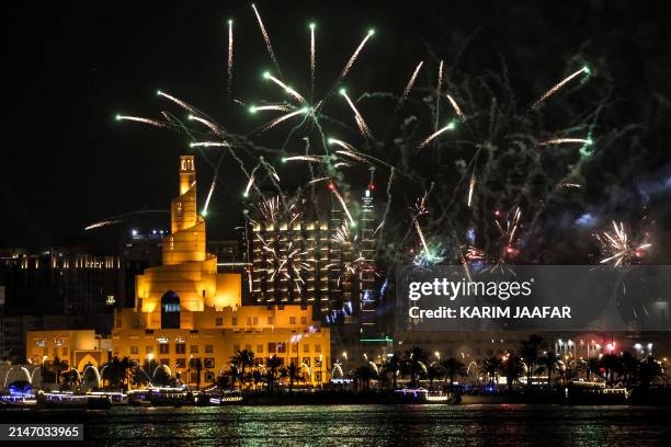 Fireworks light up the sky over the Fanar Mosque with its spiral minaret by the Doha Corniche during celebrations on the first day of the Muslim...