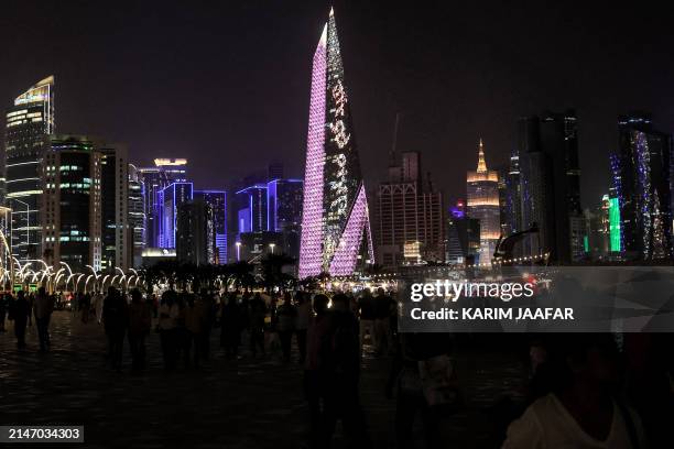 The Burj Al-Mana highrise tower in Doha is lit up with greeting messages for Eid al-Fitr on the first day of the Muslim holiday after the end of the...