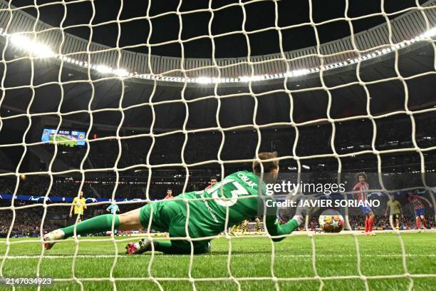 Atletico Madrid's Slovenian goalkeeper Jan Oblak jumps to make a saver during the UEFA Champions League quarter final first leg football match...