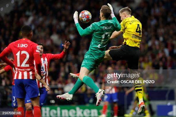 Atletico Madrid's Slovenian goalkeeper Jan Oblak jumps for the ball next to Dortmund's German defender Nico Schlotterbeck during the UEFA Champions...