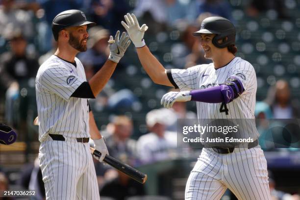 Michael Toglia of the Colorado Rockies is congratulated on his two run home run by Jacob Stallings in the fourth inning against the Arizona...