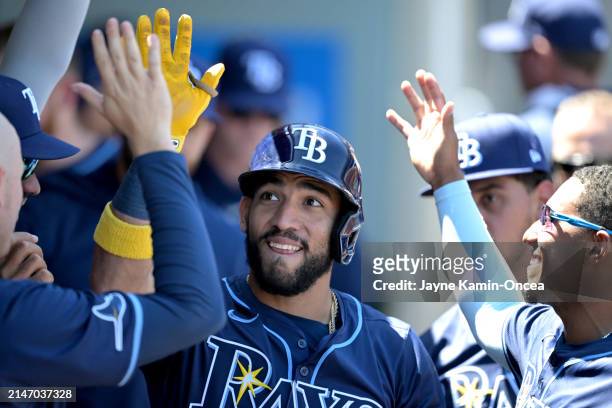 José Caballero of the Tampa Bay Rays is congratulated in the dugout after hitting a solo home run in the second inning against the Los Angeles Angels...