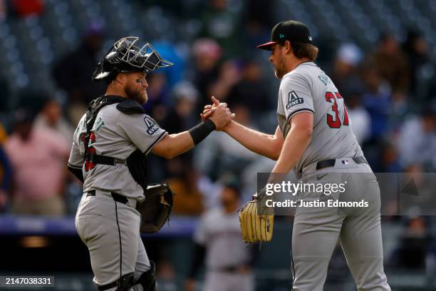 Catcher Tucker Barnhart and relief pitcher Kevin Ginkel of the Arizona Diamondbacks celebrate after the final out against the Colorado Rockies at...