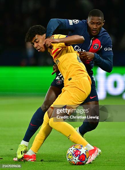 Lamine Yamal of Barcelona and Nuno Medes of PSG in action during the ...