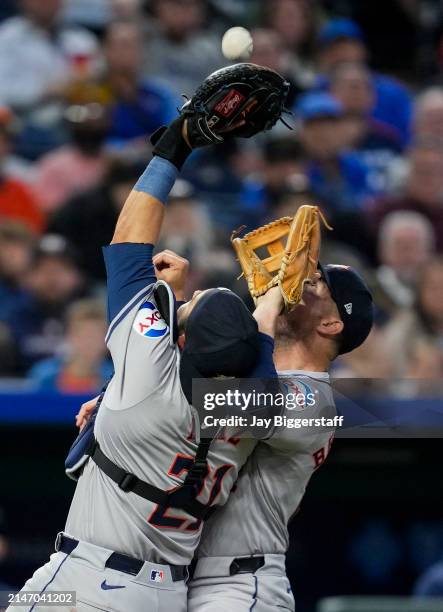 Yainer Diaz of the Houston Astros catches a pop fly as he collides with Alex Bregman during the third inning against the Kansas City Royals at...