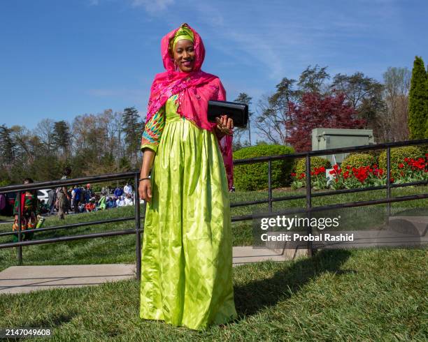 Woman poses for a photograph as she gathers to perform Eid al-Fitr prayer at the Dar Alnoor Islamic Community Center. Muslims of different...