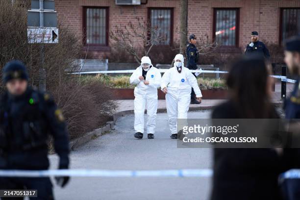 Police officers work on the scene after a person was shot dead in Skarholmen in southern Stockholm, Sweden in the evening before on April 11, 2024....