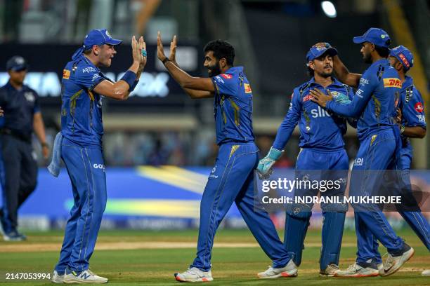 Mumbai Indians' Jasprit Bumrah celebrates with teammates after taking the wicket of Royal Challengers Bengaluru's Virat Kohli during the Indian...