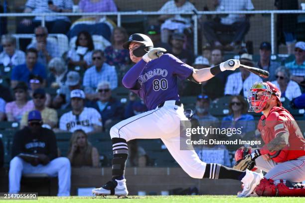 Aaron Schunk of the Colorado Rockies hits a double during the eighth inning of a spring training game against the Cincinnati Reds at Salt River...