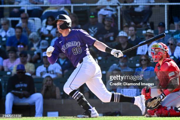 Aaron Schunk of the Colorado Rockies hits a double during the eighth inning of a spring training game against the Cincinnati Reds at Salt River...