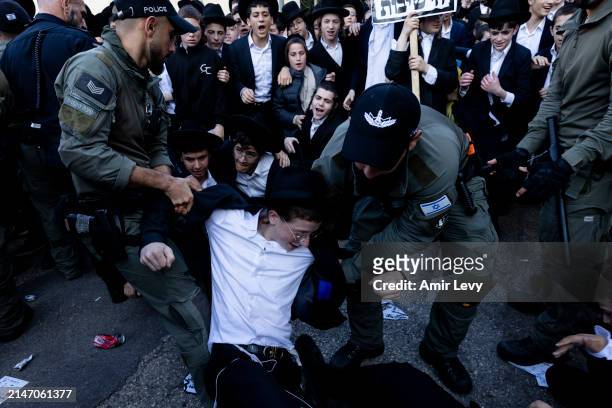 Ultra-Orthodox Jews clash with police officers during a demonstration against drafting to the IDF on April 11, 2024 in Jerusalem. Haredi men of...