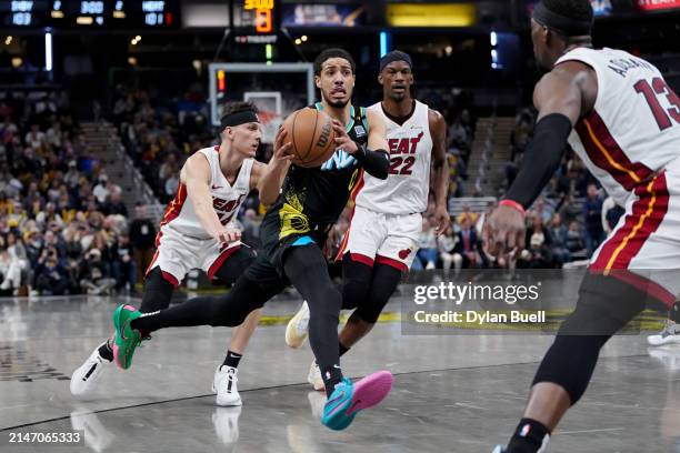Tyrese Haliburton of the Indiana Pacers dribbles the ball while being guarded by Tyler Herro of the Miami Heat in the fourth quarter at Gainbridge...