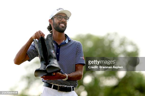 Akshay Bhatia of the United States poses with the cowboy boots after winning the Valero Texas Open on the 18th hole of the first playoff during the...
