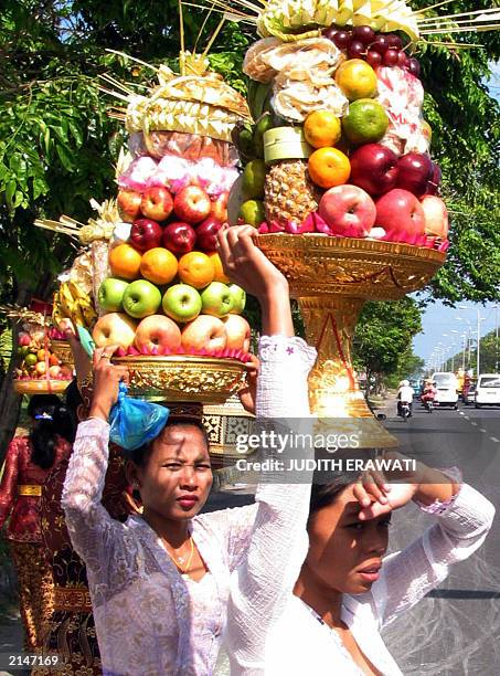 Balinese women carry offerings on their head during a Galungan traditional ceremony at Penataran temple in Denpasar Bali, 18 June 2003. Balinese...