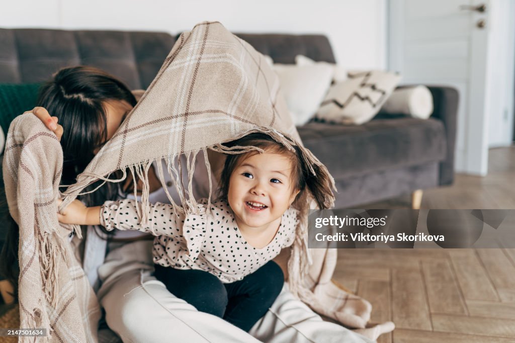 Mom and daughter wrapped in a blanket, Asian