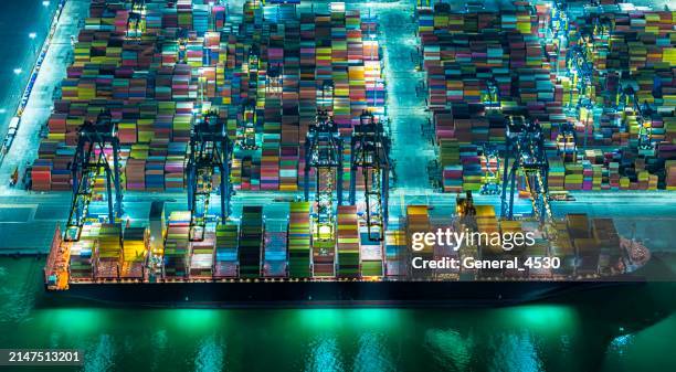 aerial view container terminals at night. - trade war stock pictures, royalty-free photos & images