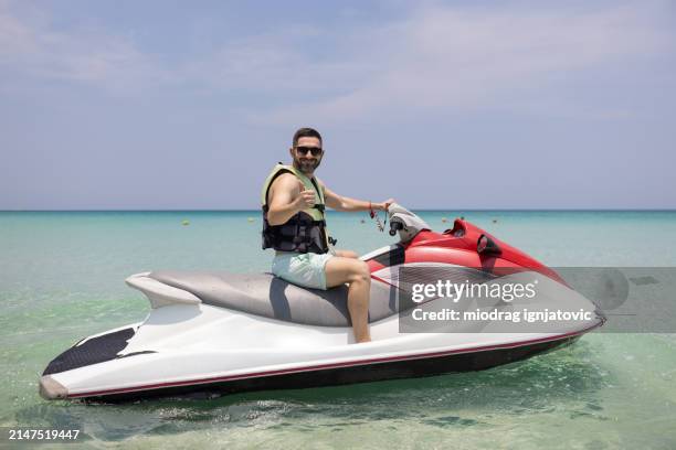 homme chevauchant un jet boat - jet ski photos et images de collection