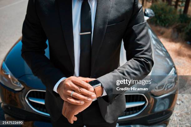 successful businessman checking time near luxury car - luxeauto stockfoto's en -beelden